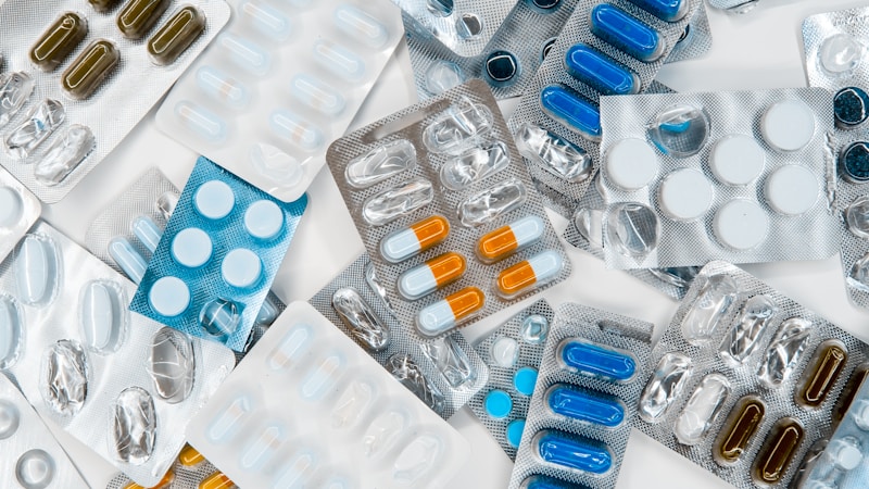 Person holding prescription bottle while reviewing insurance documents and pharmacy receipt